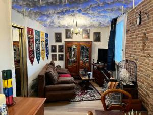 a living room with a couch and a tv at Le Refuge mysterieux d'Harry proche Gare Toulouse in Toulouse