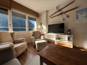 a living room with a couch and a tv at Baqueira1500, apartamento con vistas a pie de pistas in Naut Aran