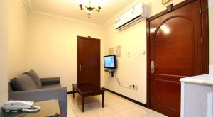 a living room with a couch and a tv on the wall at Jumeirah in Jeddah