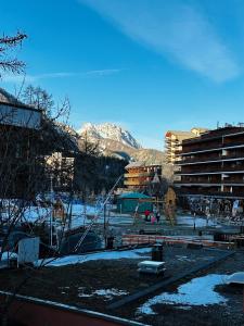 een speeltuin in een stad met een besneeuwde berg bij Pra Loup 1600 in Uvernet