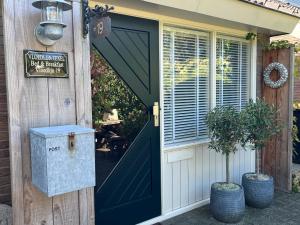a door to a house with a sign on it at B&B Vloedlijn Texel in Den Burg