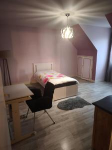 een slaapkamer met een bed, een bureau en een stoel bij MAISON Aéroport CDG Parc des expos Villepinte Bourget Astérix in Goussainville
