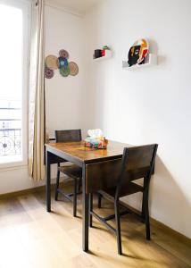 een eettafel met 2 stoelen en een tafel bij Le Petit Kandinsky in Le Kremlin-Bicêtre +2 foto's