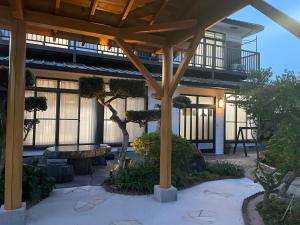 南房総市にある仲間の宿 川きんのパーゴラ付きの建物、木々のある中庭