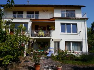 Dieses weiße Haus verfügt über einen Balkon und eine Terrasse. in der Unterkunft Haus Brand in Bad Kissingen