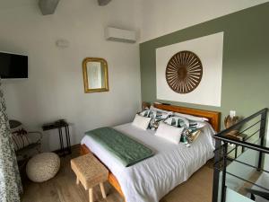 ein Schlafzimmer mit einem Bett und einem Spiegel an der Wand in der Unterkunft Maison avec ses 2 terrasses et sa piscine in Eyragues + 10 Fotos