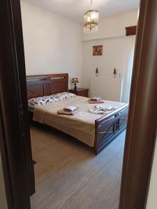 a bedroom with a large bed and a chandelier at Sweet Home Lina in Paralia Katerinis