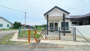 a small house with a gate in front of it at Homestay Rumah 2081 in Tumpat