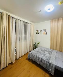 a bedroom with white curtains and a bed in it at Wanderer's Home at Seawind Condo near Davao Airport in Davao City +6 photos