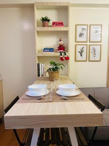 a dining room table with two white dishes on it at Wanderer's Home at Seawind Condo near Davao Airport in Davao City