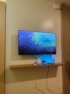 a flat screen tv sitting on a shelf on a wall at Wanderer's Home at Seawind Condo near Davao Airport in Davao City