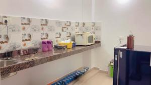 a kitchen with a sink and a microwave on a counter at Kashi Paradise in Varanasi
