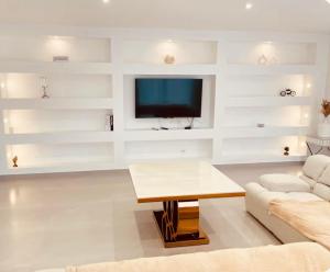 a living room with a couch and a tv at Villa 220 m2 avec 5 chambres 6 lits doubles 2 toilettes 2 salles de bain in Beire-le-Châtel