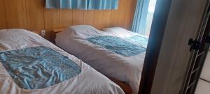 two twin beds in a room with a window at Miyagi Apartment Tomari in Naha
