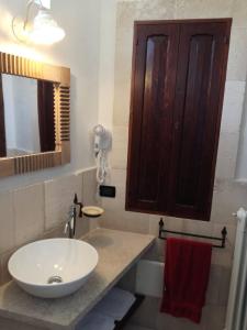 a bathroom with a white sink and a mirror at Casa vacanze in Dimora Storica del 1500 in Martano +10 photos