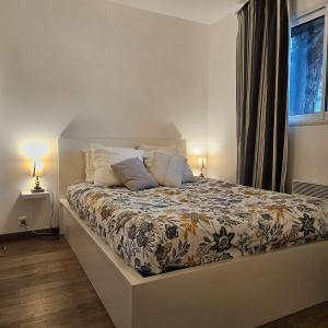 a bed in a bedroom with two lamps and a window at Baie du Mont-Saint-Michel et Côte Normande - Les Secrets du Rivage in Saint-Pair-sur-Mer