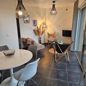 a living room with a table and chairs at Baie du Mont-Saint-Michel et Côte Normande - Les Secrets du Rivage in Saint-Pair-sur-Mer