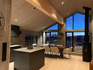a kitchen and dining room with a table and chairs at New modern cabin in Beitostølen in Beitostøl