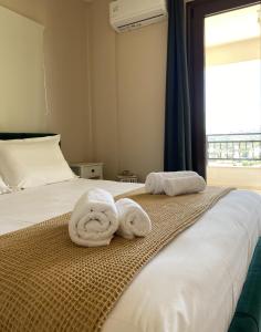 a bedroom with two towels on a bed with a window at Mons Apartments in Spílion