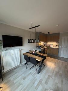a living room with a table and a kitchen at Fewo Chill und Meer in Horumersiel +26 photos