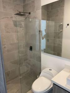 a bathroom with a toilet and a glass shower at Sensacional Apto NUEVO con Vista al Mar in Gustavo Rojas Pinilla International