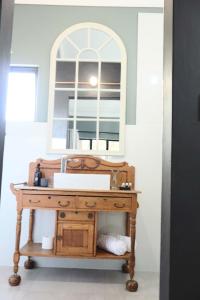 a bathroom with a wooden vanity with a mirror at Febe-Mari Guesthouse in Zeerust +54 photos