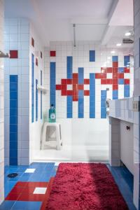 a bathroom with a red rug on the floor at Domus Palestro in Rome