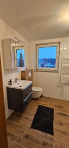 a bathroom with a sink and a toilet and a window at Ferienwohnung Alte Wache 12 DG in Holzminden