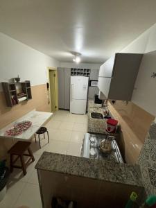 a kitchen with a sink and a white refrigerator at Apartamento quadra mar, 1 dos quartos com ar-condicionado , Barra Sul in Balneário Camboriú
