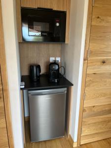 a kitchen with a microwave and a small refrigerator at Cabane de Combe Falce in Salignac Eyvigues