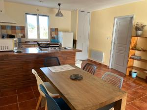 a kitchen with a wooden table and chairs at Gîte de Combe Falce in Salignac Eyvigues