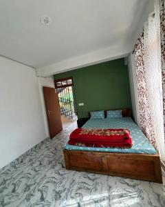 Un dormitorio con una cama con una pared verde. en Krishna Maya Homestay, en Kalimpong 14 fotos más