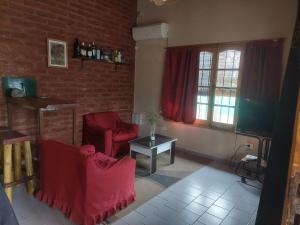 サン・ラファエルにあるLa Brujita, casa de campoの赤い椅子とレンガの壁のあるリビングルーム