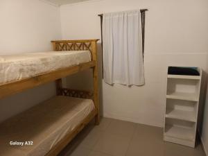 a small room with two bunk beds and a window at Casa Quequen in Quequén