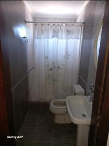 a bathroom with a toilet and a sink at Casa Quequen in Quequén +14 photos