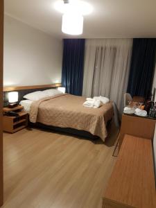 a hotel room with a large bed and blue curtains at ORBI PALACE DeLuxe nice apartment in Bakuriani +25 photos