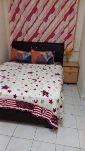 Schlafzimmer mit einem Bett mit einer roten und weißen Bettdecke in der Unterkunft Bentong Hill Cottage in Bentong