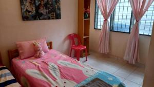 a bedroom with a bed with a teddy bear on it at Bentong Hill Cottage in Bentong