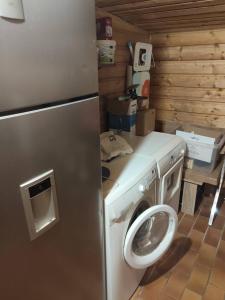 une cuisine avec un réfrigérateur et une machine à laver dans l'établissement La Corbassière, à Murs-et-Gélignieux