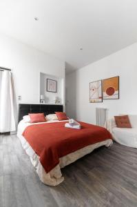 a bedroom with a large bed with a red blanket at Residence Germot - Maison et Appartements design proche Thermes in Vichy