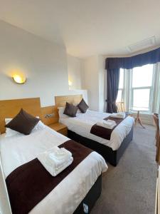 a hotel room with two beds and a window at Four Saints Brig Y Don Hotel in Llandudno +93 photos