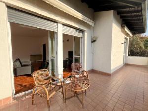 a patio with two chairs and a table on a house at Villa nel Parco dei Ronchi in Legnano
