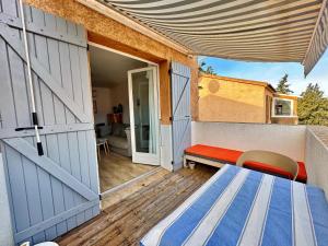 a door to a balcony with a table and a bench at Appartement Calvi A Moresca in Calvi