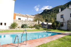 a swimming pool in front of a house at Casa Rural El Vihuelo in El Bosque
