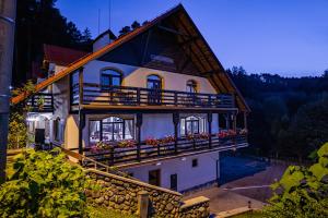 ein Haus mit einem Balkon, der mit Blumen bedeckt ist in der Unterkunft Q Chalet in Săcele
