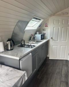 a kitchen with a stove and a sink and a door at Gortin Glen Glamping in Omagh +20 photos