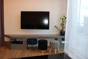 sala de estar con TV y 2 taburetes en Villa L'Oasis, en Aytré