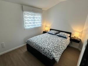 a bedroom with a bed with two pillows and a window at Agréable maison neuve de plain pied in Villiers-le-Sec