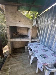 a table and chairs on a porch with a fireplace at Tindet in Playa Hermosa