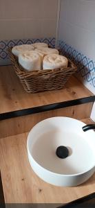 una ciotola bianca su un bancone con un cesto di asciugamani di Candela con amor a Punta Umbría